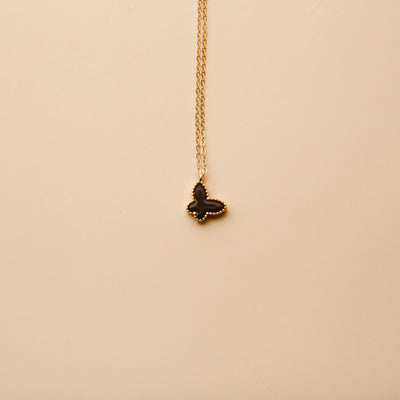 Gold butterfly pendant necklace with a black enamel finish, offering a timeless, elegant design for everyday wear and thoughtful gifting.