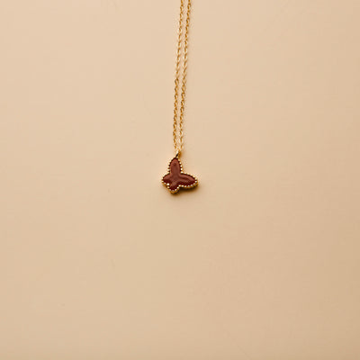 Gold butterfly pendant necklace with a red enamel finish, offering a timeless, elegant design for everyday wear and thoughtful gifting.
