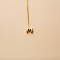Gold letter M pendant necklace with a polished finish, offering a timeless, personalized design for everyday wear and thoughtful gifting.