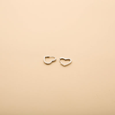 Silver heart hoop earrings with sparkling crystal accents, offering a timeless, elegant design for everyday wear and special occasions.