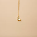 Gold letter L pendant necklace with a polished finish, offering a timeless, personalized design for everyday wear and thoughtful gifting.