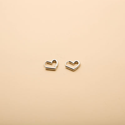 Silver heart hoop earrings with a timeless, minimalist design, perfect for everyday wear and effortless style.