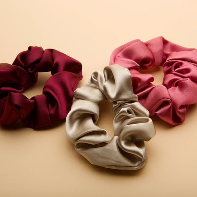 Soft satin scrunchie set in burgundy, pink, and silver, designed for a gentle hold, everyday comfort, and effortless style.