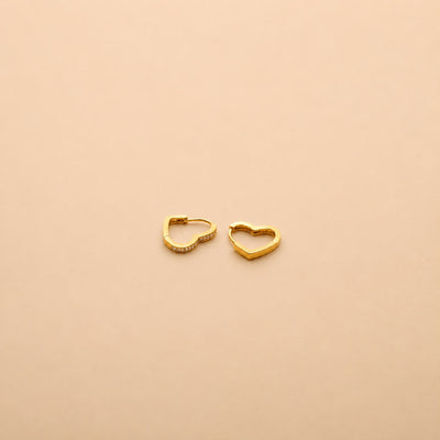 Gold heart hoop earrings with sparkling crystal accents, offering a timeless, elegant design for everyday wear and special occasions.